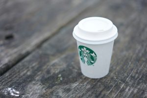 A to-go cup showing the drink hole misaligned with the logo printed on the cup.
