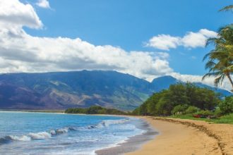 A beautiful sandy beach and tropical blue waters on the island of Maui.